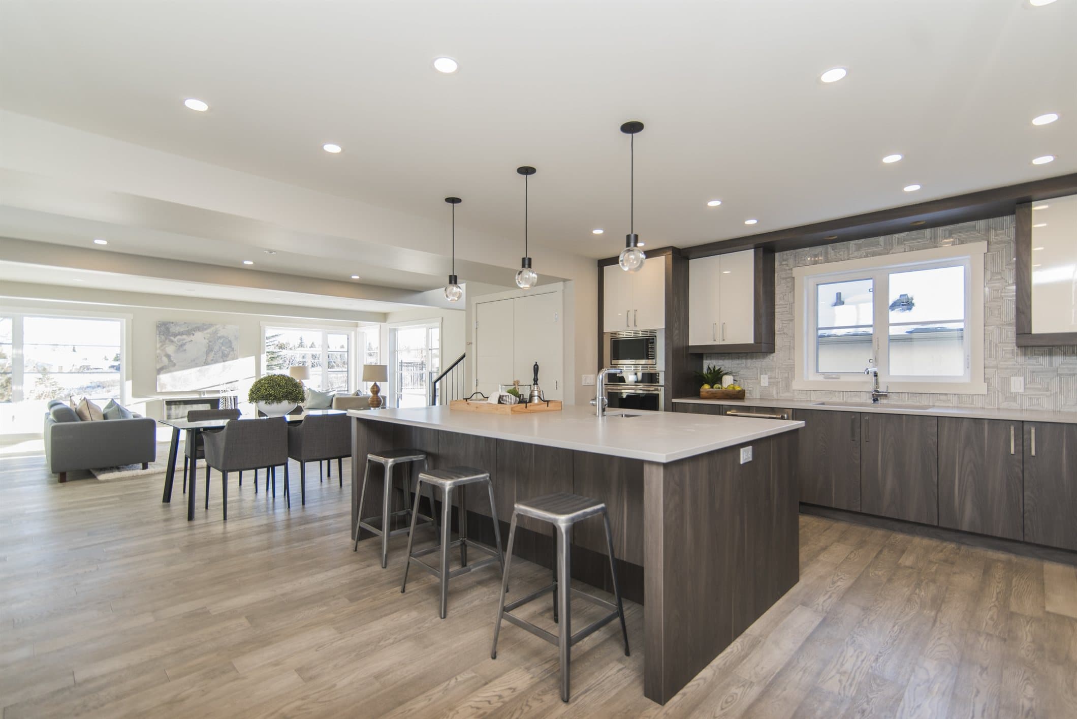 A renovated open-plan kitchen with a large island, pendant lights and bar stools